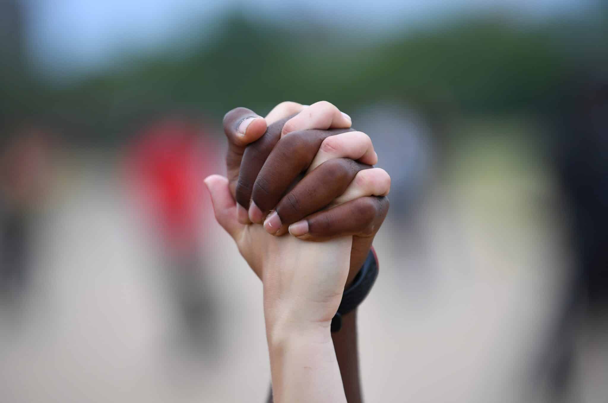 A man and woman hold hands in London's Hyde Park during a "Black Lives Matter" protest June 3, 2020, following the death of George Floyd, an African American man who was taken into custody by Minneapolis police and later died at a Minneapolis hospital. (CNS photo/Dylan Martinez, Reuters)