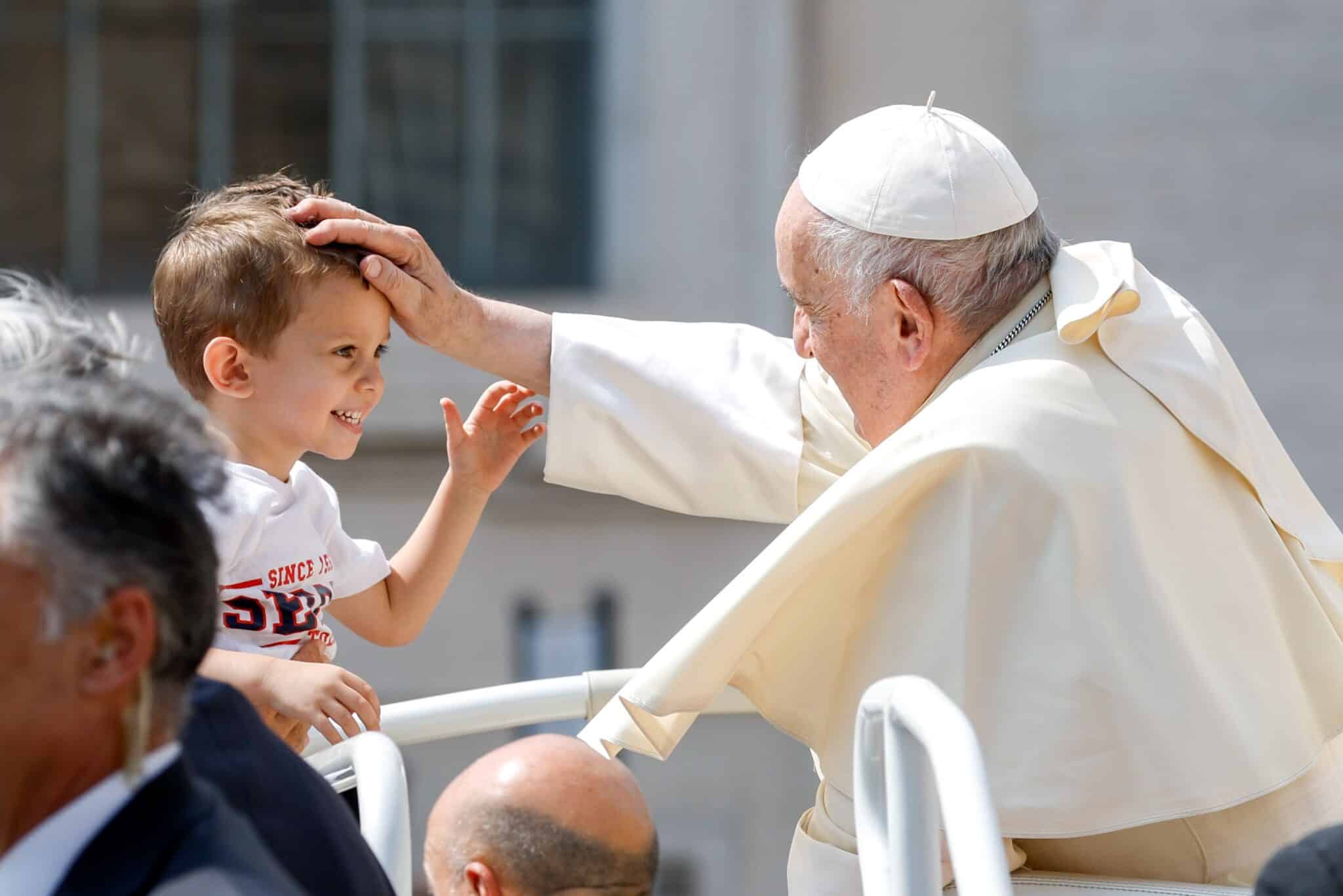 Pope Francis greets a child as he rides in the popemobile leaving St. Peter's Square at the Vatican after his weekly general audience June 28, 2023. (CNS photo/Lola Gomez)