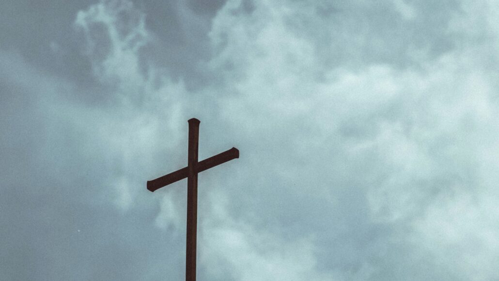 Cross and a gray sky | Photo by Markus Schumacher on Unsplash