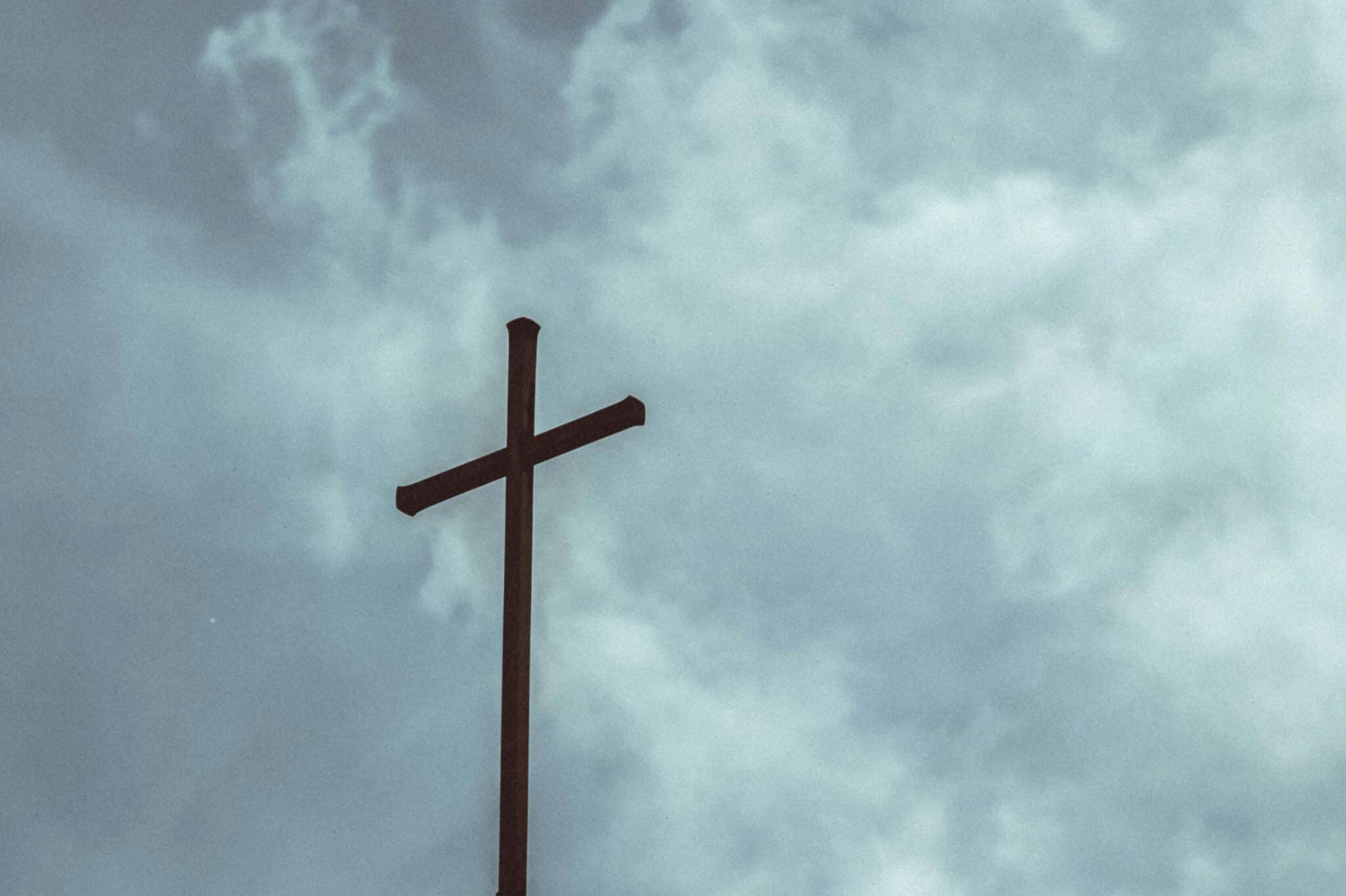 Cross and a gray sky | Photo by Markus Schumacher on Unsplash