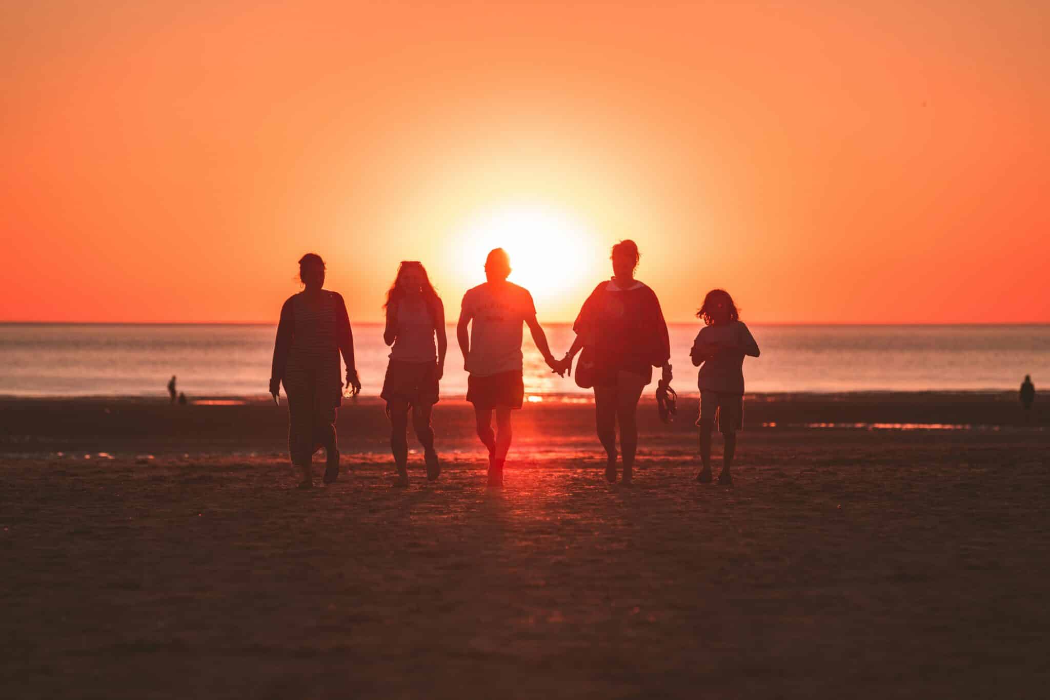 Family walking on the beach | Photo by Kevin Delvecchio on Unsplash