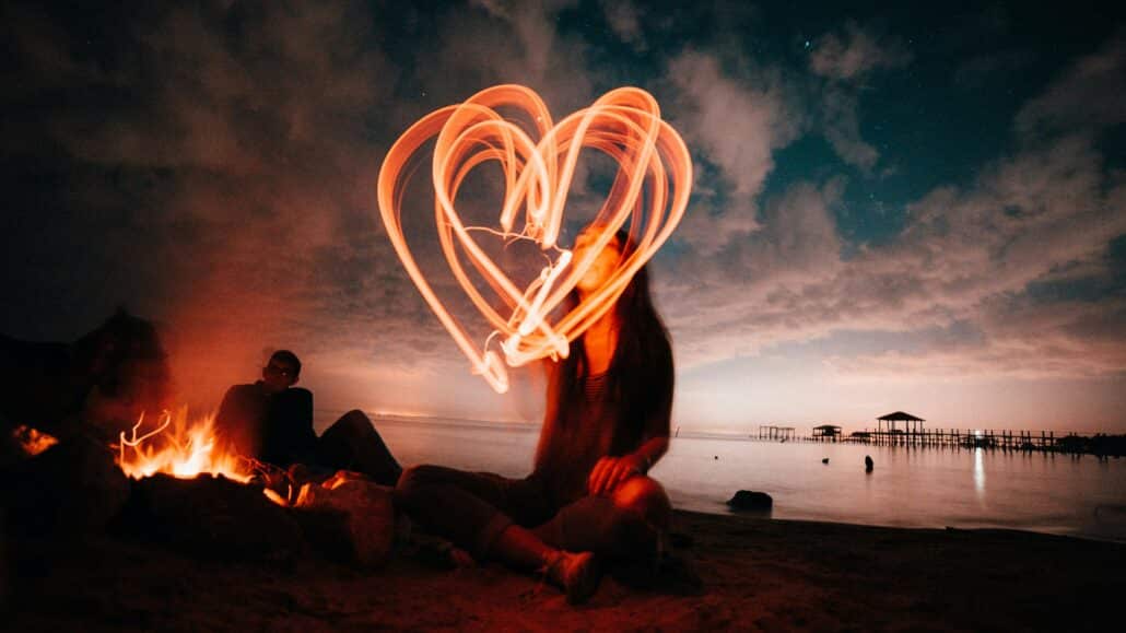 Woman making a heart out of light | Photo by Rhand McCoy on Unsplash