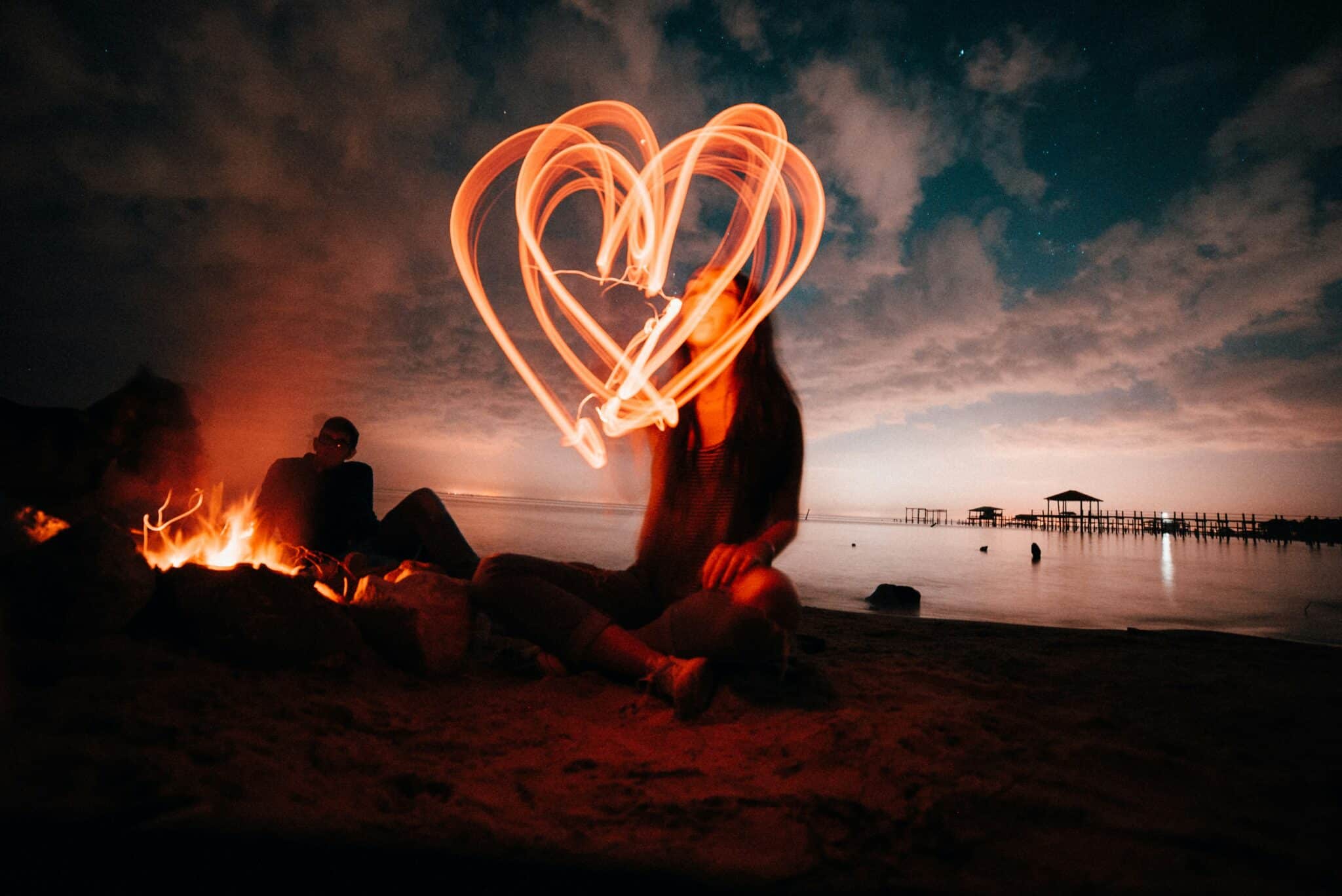 Woman making a heart out of light | Photo by Rhand McCoy on Unsplash
