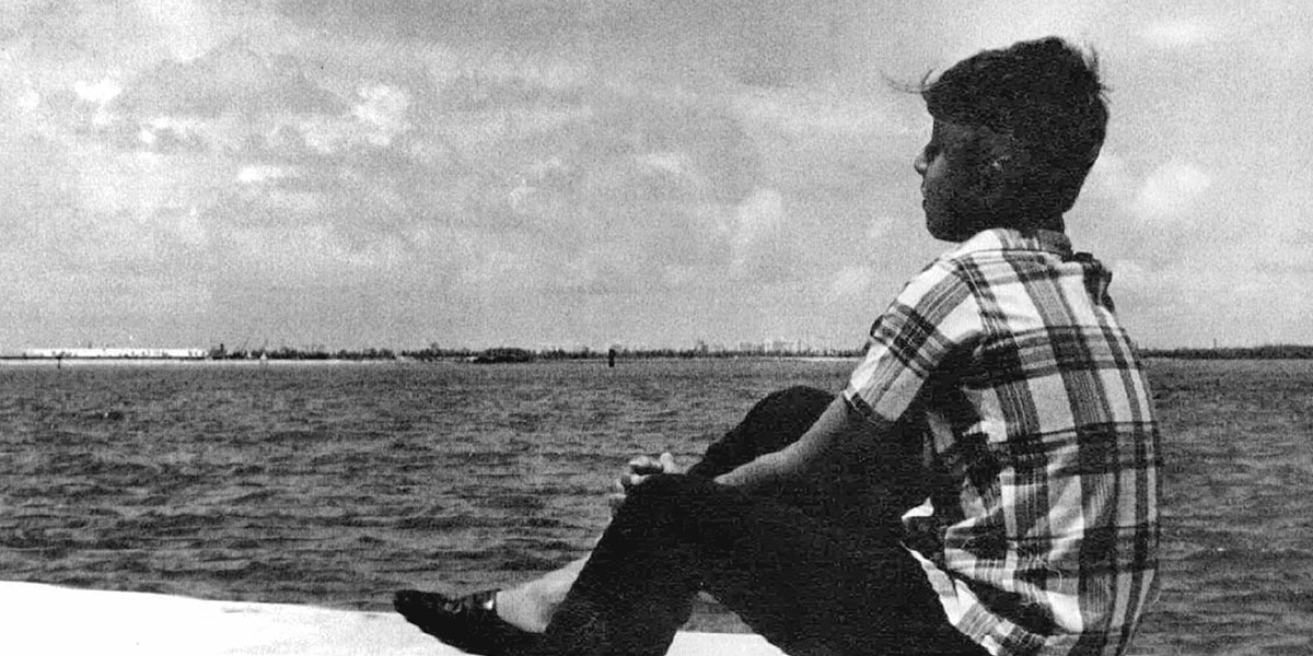 A young boy looks out into the ocean after Operation Pedro Pan