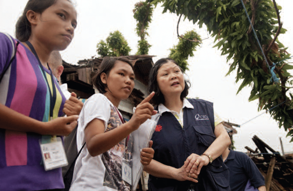 Survivors in the path of Philippines typhoon will be rebuilding for years. Here Dr. Woo visits a neighborhood in Tacloban, where Typhoon Haiyan
wreaked destruction. (Photo by Laura Elizabeth Pohl/CRS)
