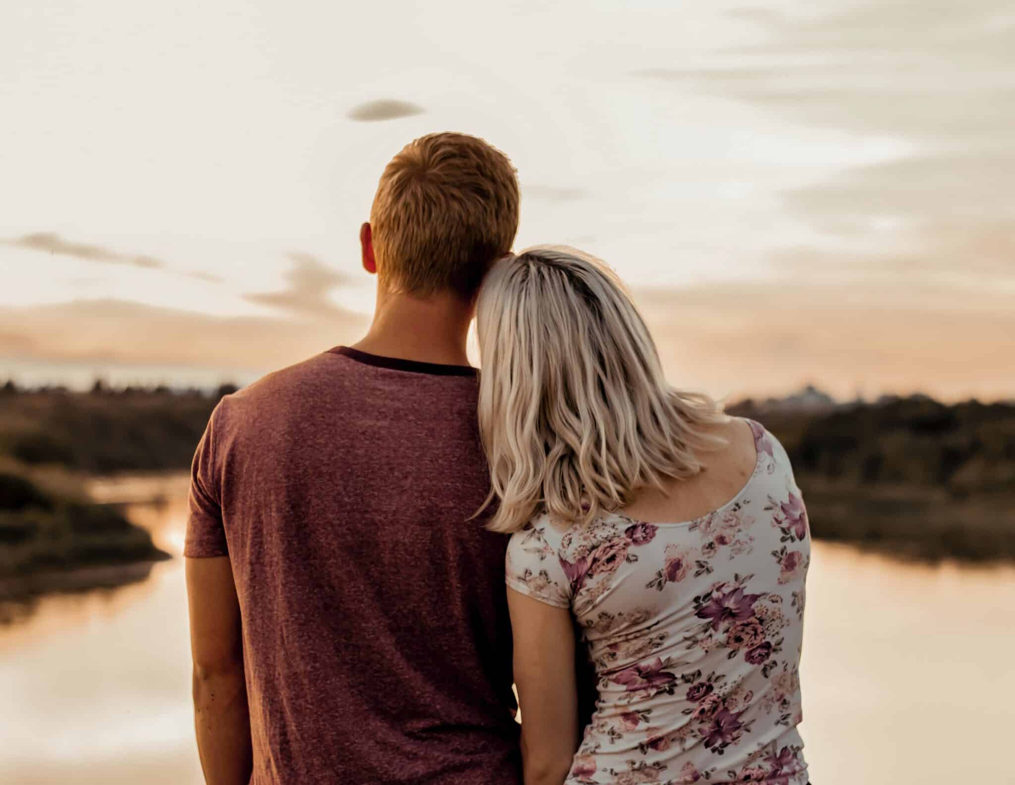 Man and woman looking at the sunset |n Photo by Mindy Sabiston on Unsplash