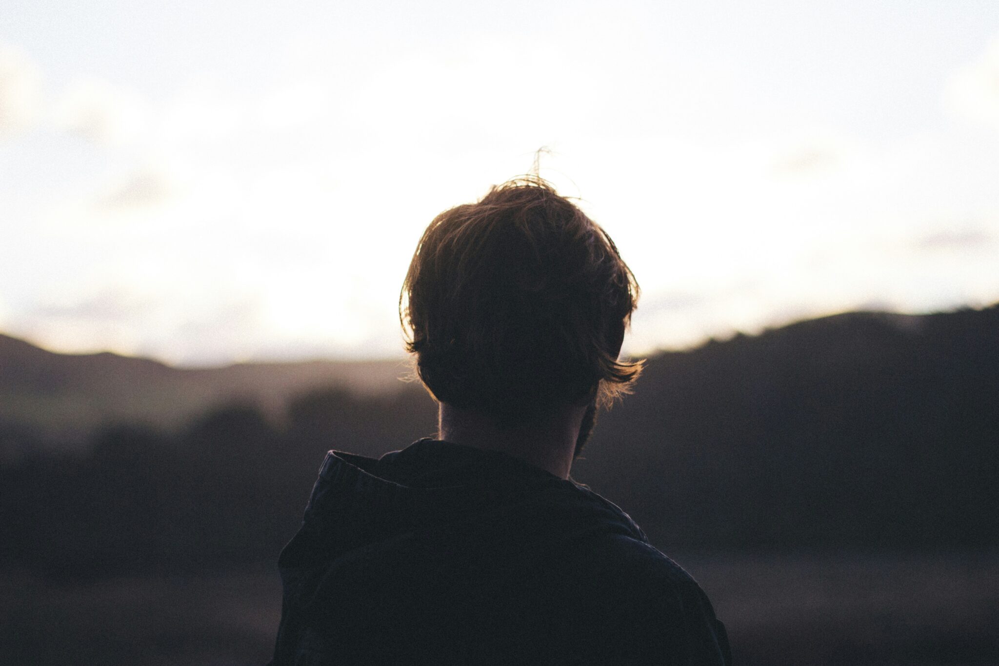 man looking at a valley | Photo by Tim Marshall on Unsplash