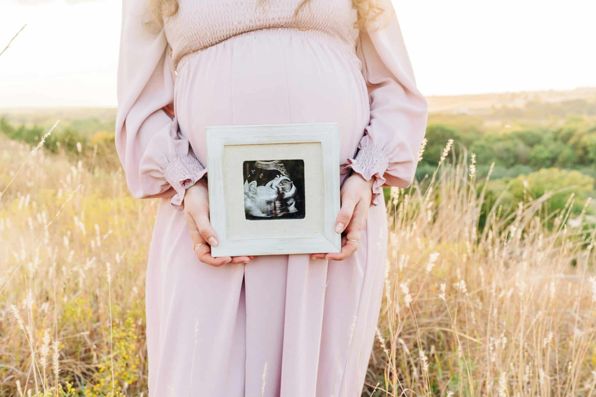 Pregnant woman holding a picture | Photo by Bethany Beck on Unsplash