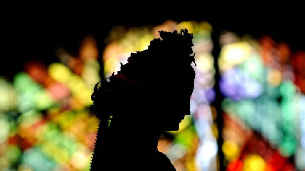 A statue of Mary adorned with a floral crown is silhouetted against a stained- glass window at St. Joseph Church in Penfield, N.Y., after a May crowning ceremony May 7. The month of May is devoted to Mary and is traditionally celebrated with a crowning and praying of the rosary. (CNS photo/Mike Crupi, Catholic Courier)