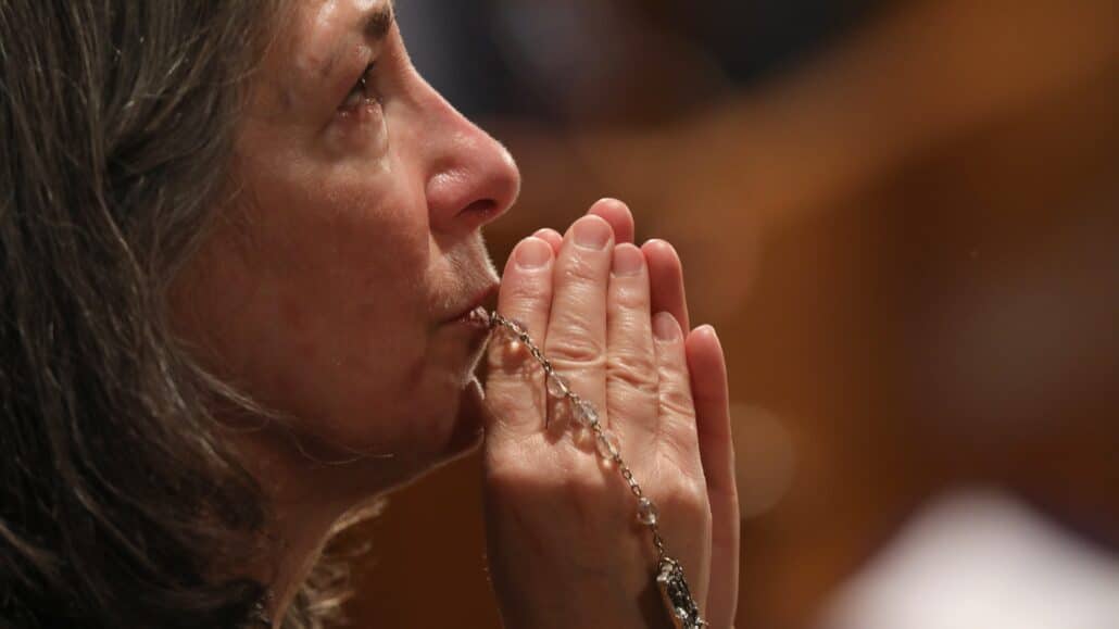 A woman becomes emotional as she prays with a rosary during Eucharistic adoration following the opening Mass of the National Prayer Vigil for Life Jan. 19, 2023, at the Basilica of the National Shrine of the Immaculate Conception in Washington. (OSV News photo/Bob Roller)