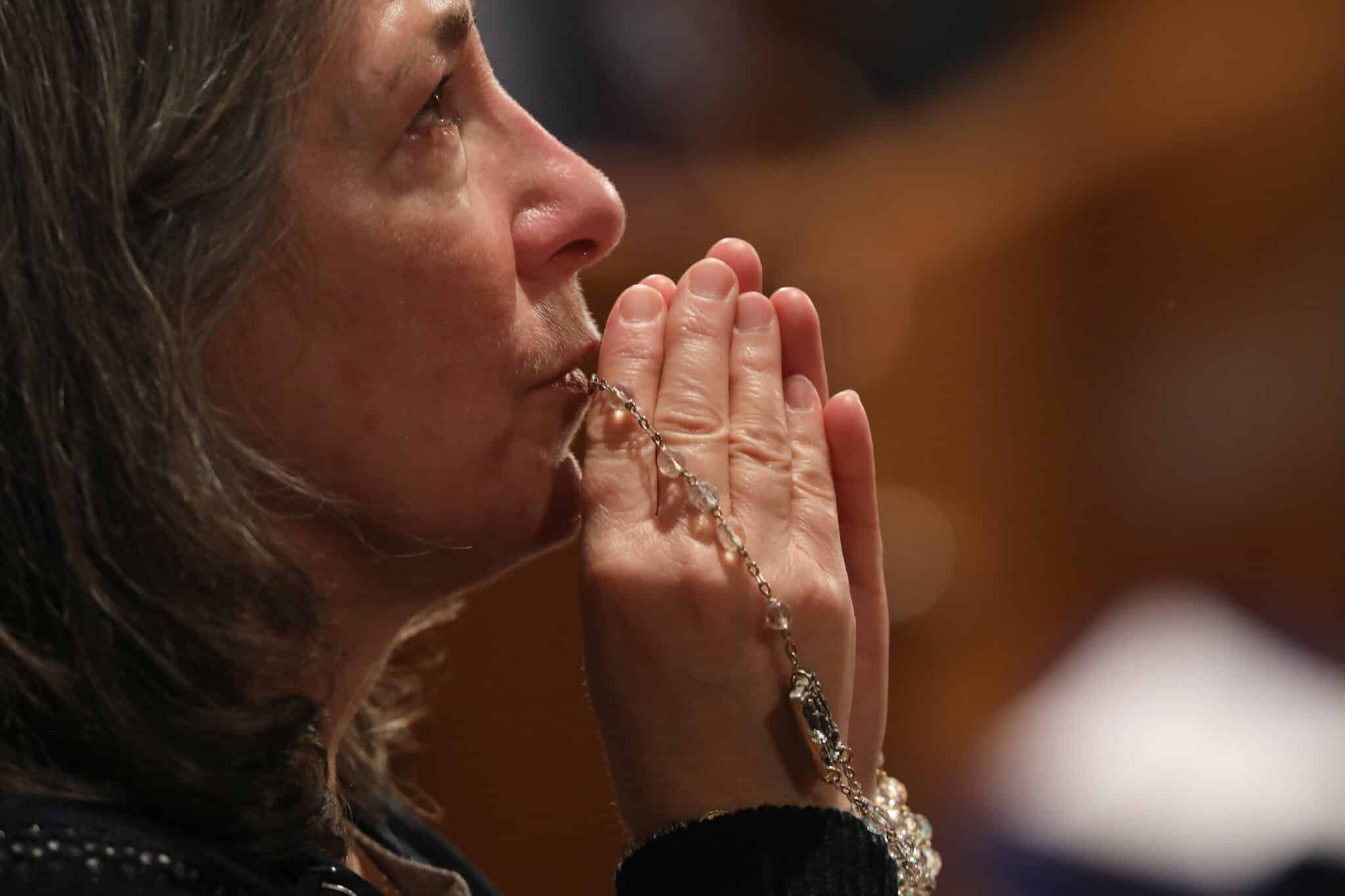 A woman becomes emotional as she prays with a rosary during Eucharistic adoration following the opening Mass of the National Prayer Vigil for Life Jan. 19, 2023, at the Basilica of the National Shrine of the Immaculate Conception in Washington. (OSV News photo/Bob Roller)