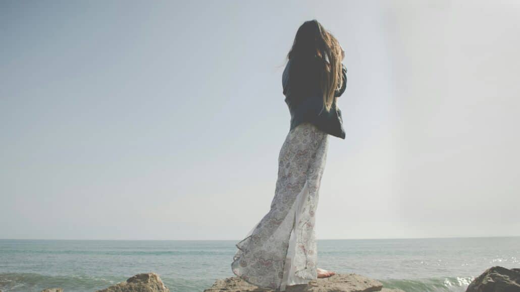 Woman standing at the ocean's edge | Photo by Yume Photography on Unsplash