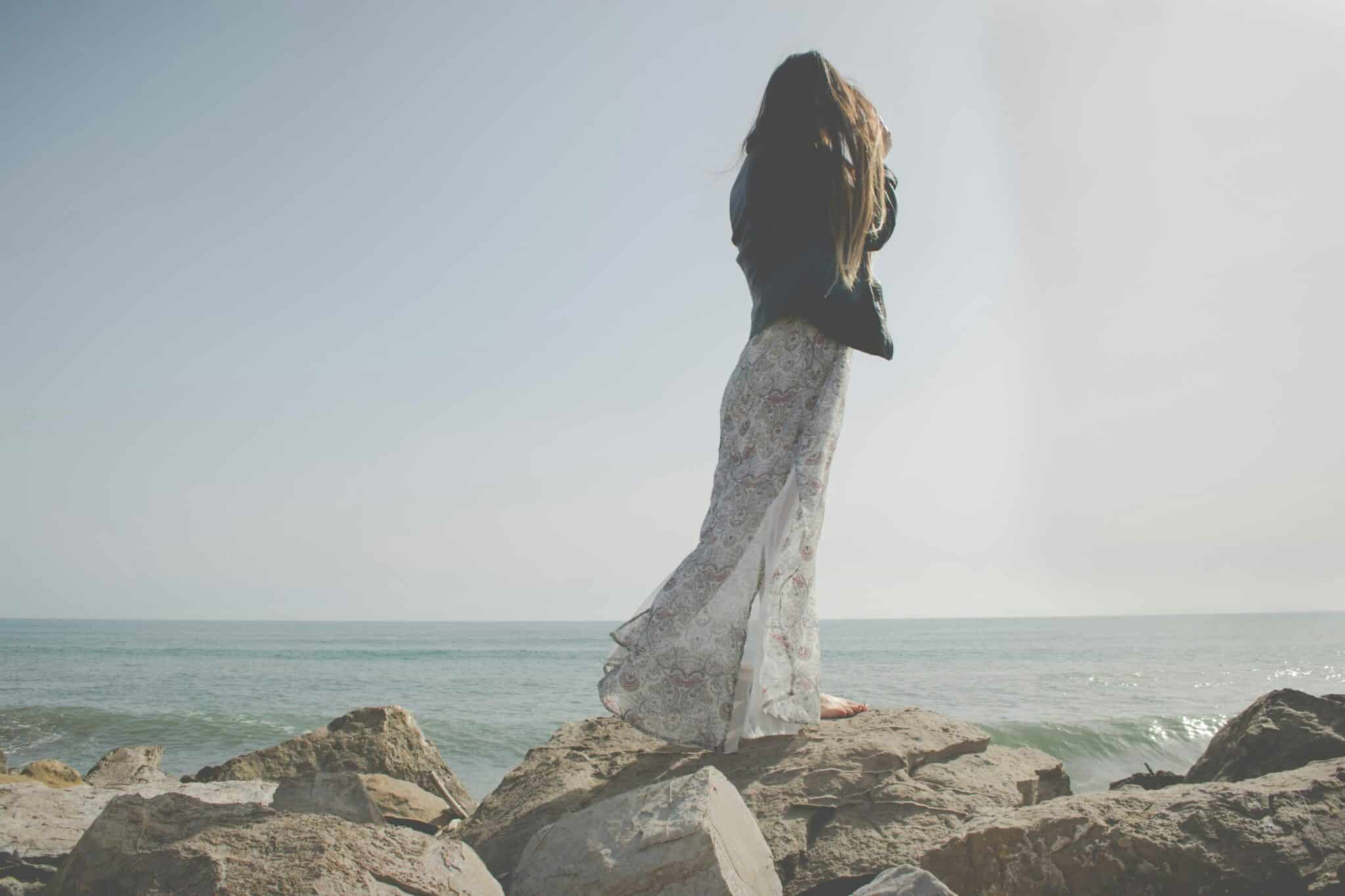 Woman standing at the ocean's edge | Photo by Yume Photography on Unsplash