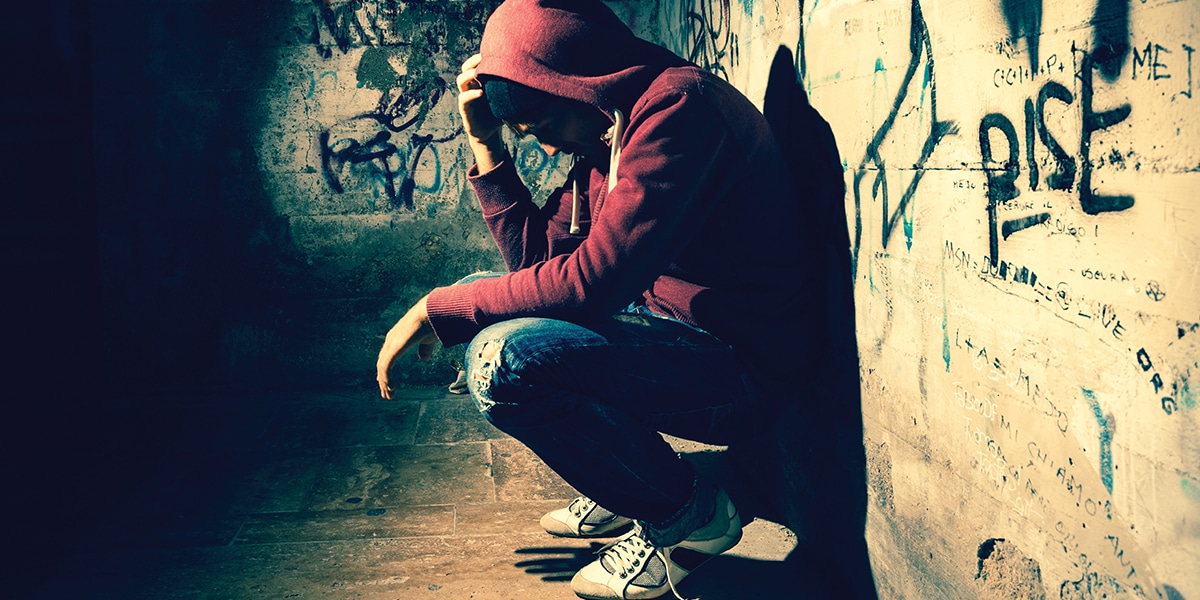 Young person resting against a wall