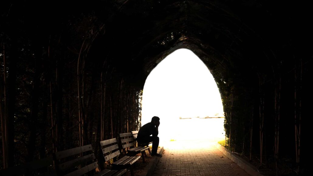 Man sitting in a dark tunnel for some reason.