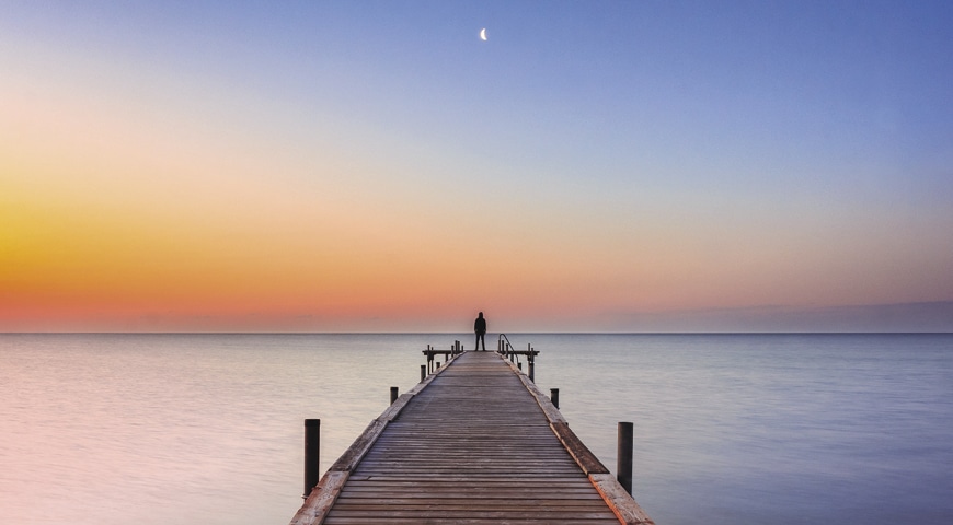 man standing at the edge of a pier
