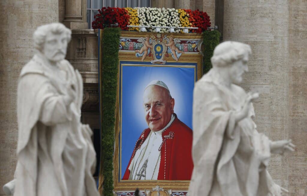 A banner depicting Saint John XXIII hangs from the facade of St. Peter's Basilica at the Vatican April 27. (CNS photo/Paul Haring) (April 27, 2014) 