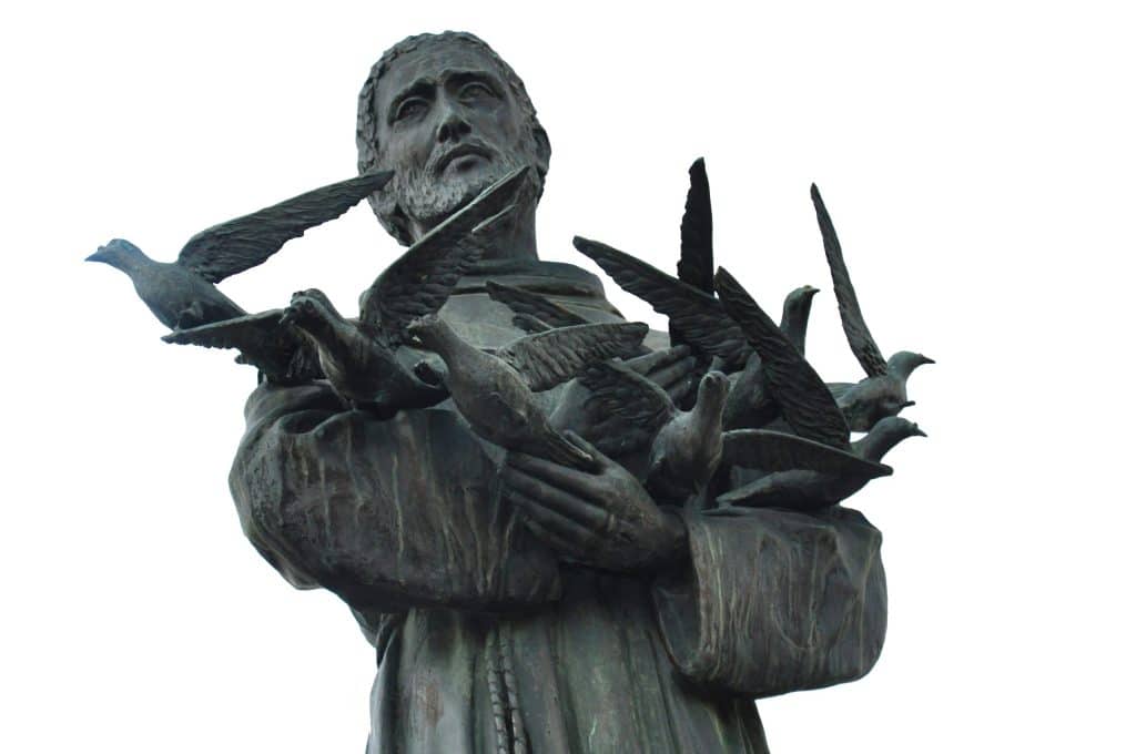 Statue of Saint Francis with birds flying around him