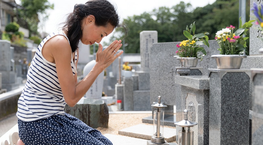 Person that appears to be praying next to a grave
