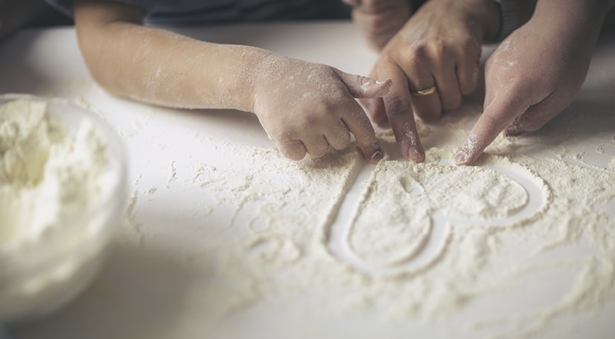 People drawing a heart in flour
