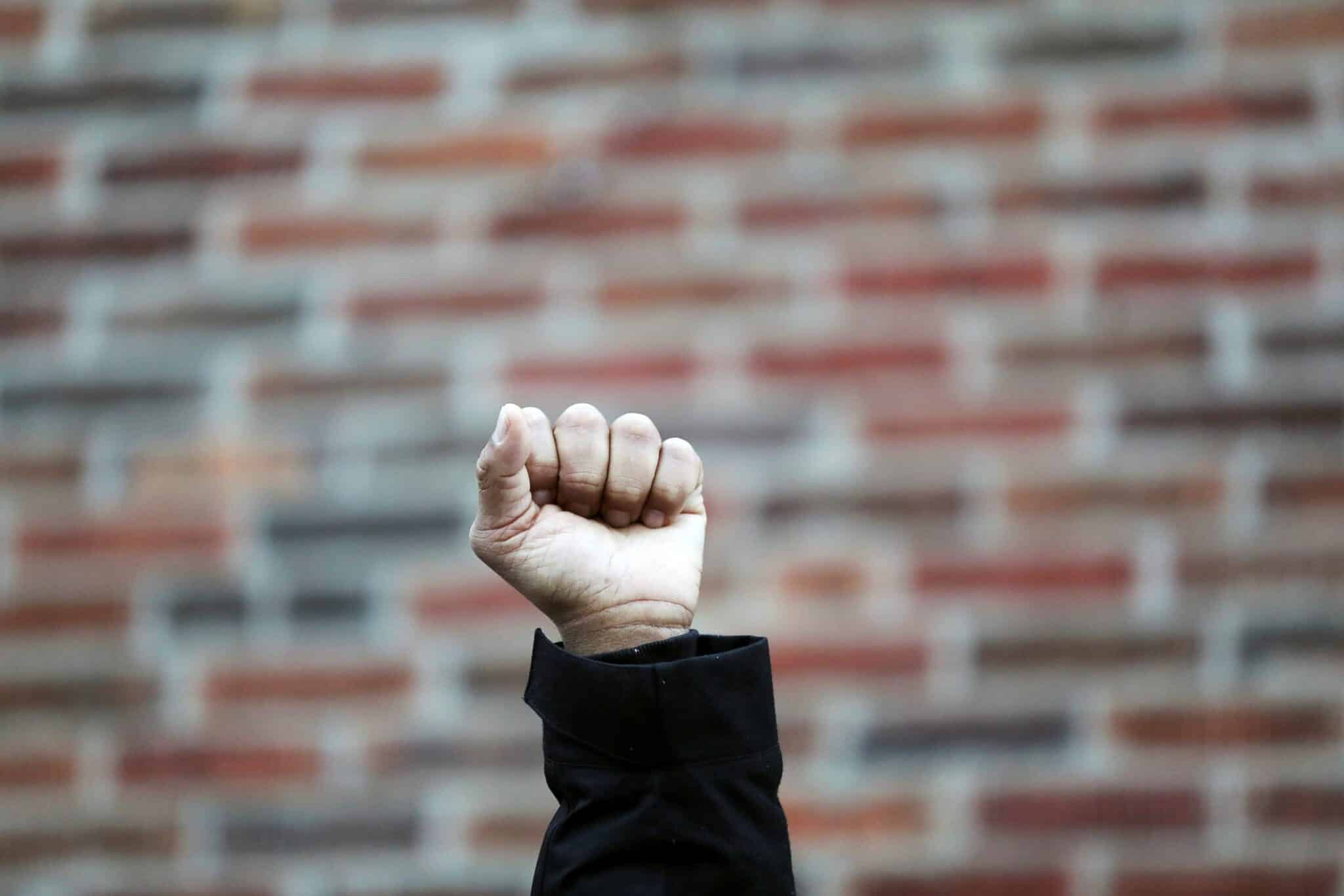 Person raising a closed fist in the air