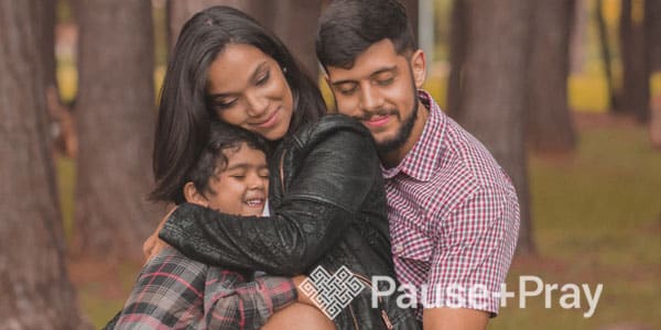 Family hugging each other with trees in background