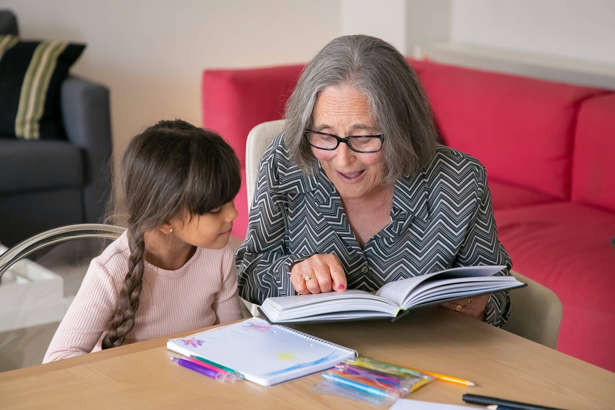 Grandmother reading granddaughter a book