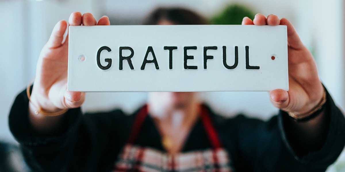 Man holding a sign that says grateful