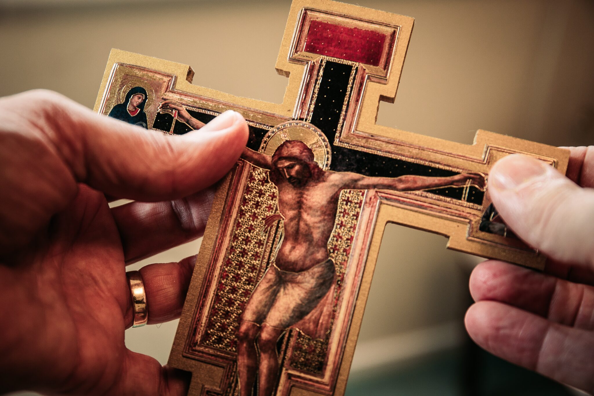 Person holds a San Damiano cross