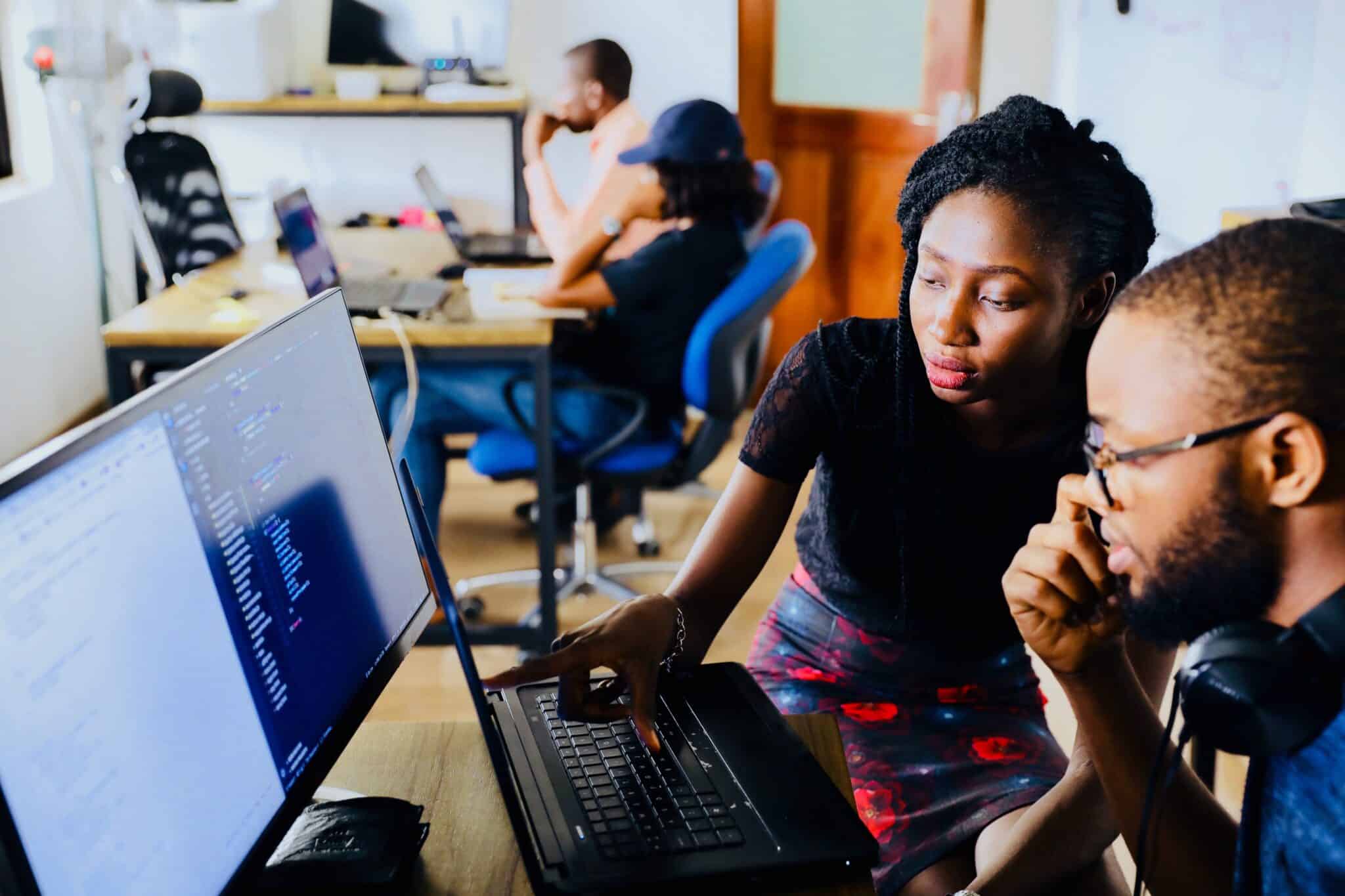 Person showing another person something on the computer