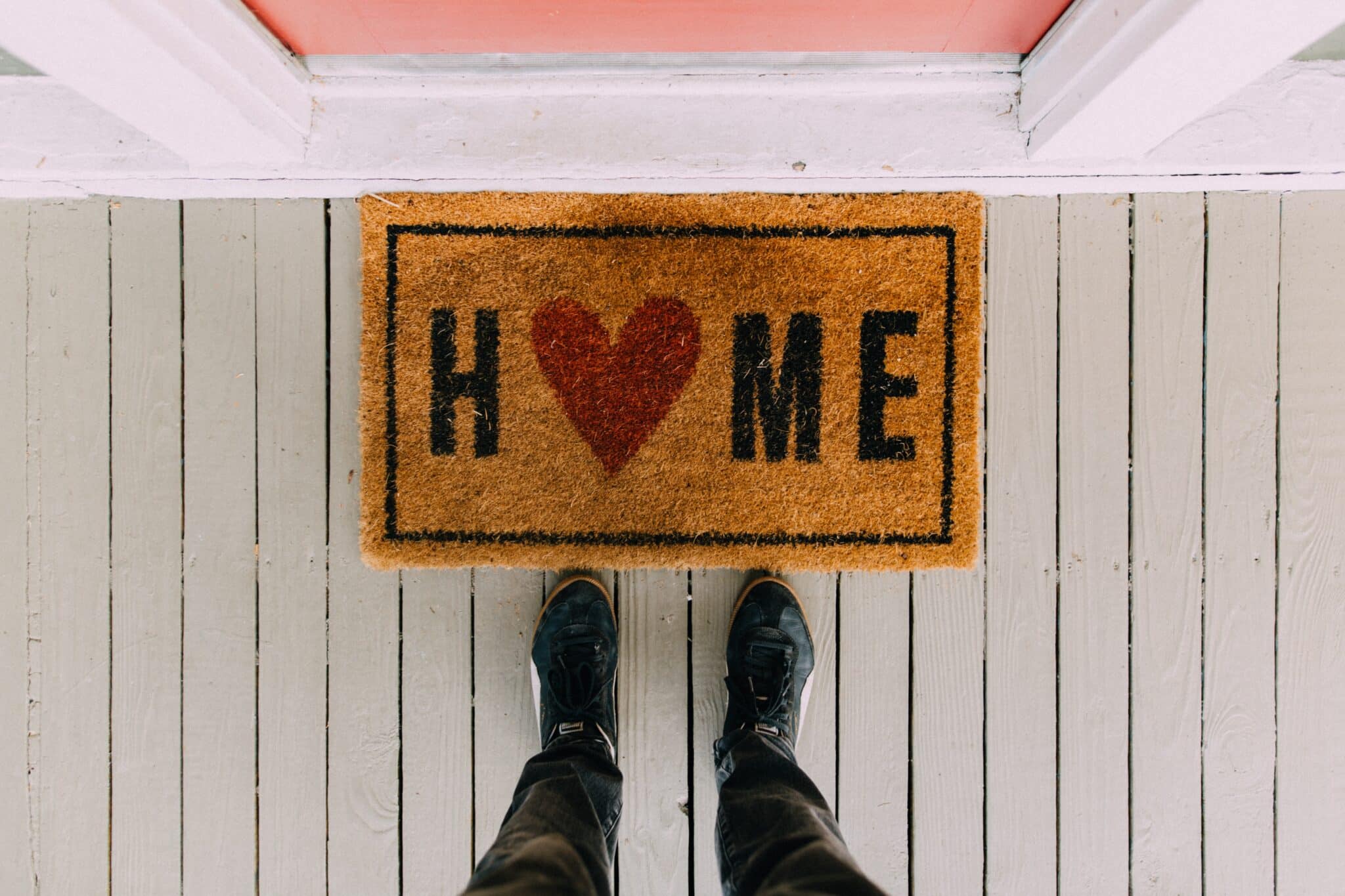 Person standing in front of a welcome mat with a heart