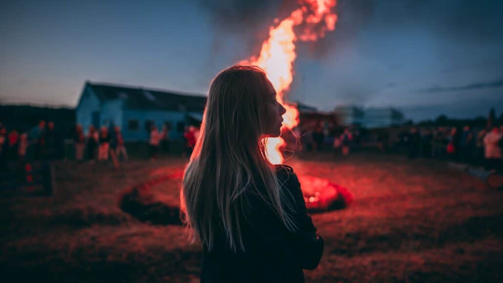 Woman standing by a bonfire