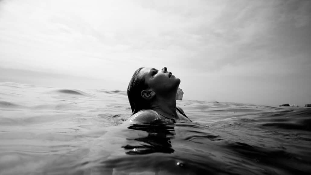 Person swimming in the water in black and white