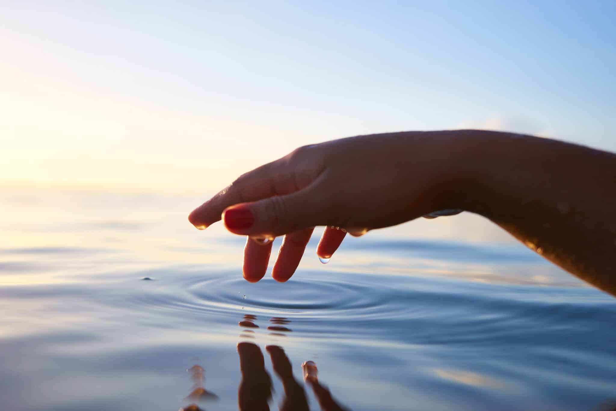 Person dipping their hand in water