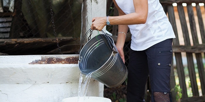 Person pouring water out of a bucket
