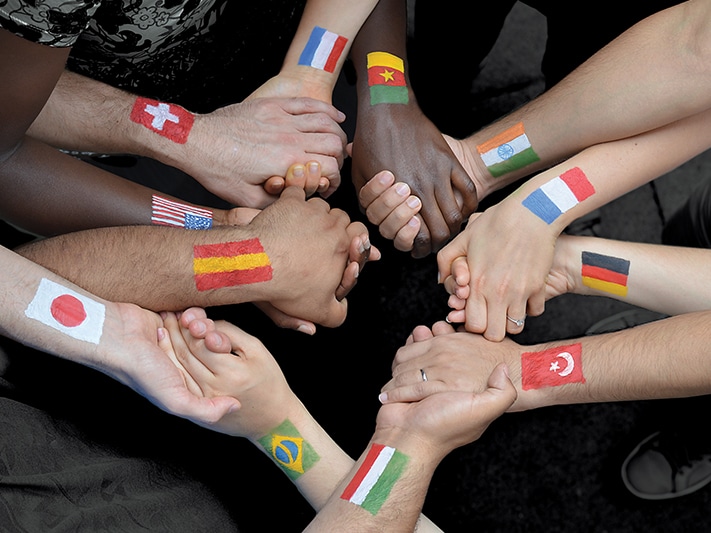 People holding hands with flags on their arms