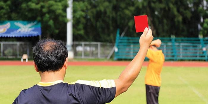 Soccer ref holding up a red card