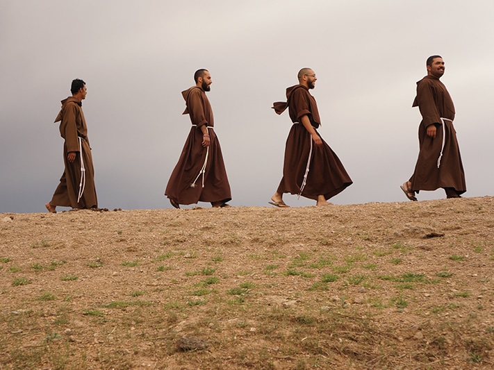 Four people walking in a line