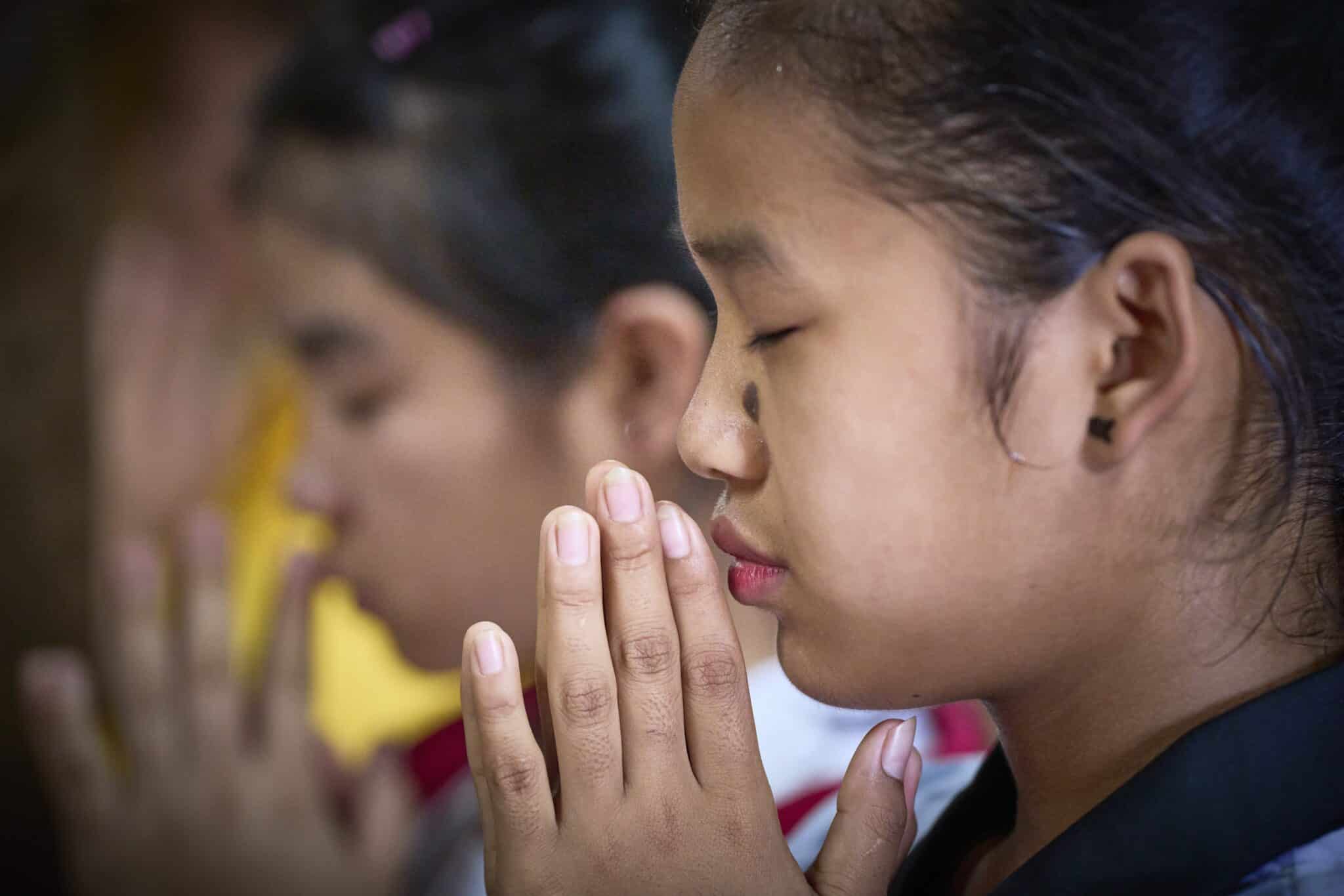 A girl prays in St. Mary's Catholic Church in the Ban Mai Nai Soi refugee camp in Thailand Sept. 27, 2022. The camp is home to thousands of refugees from Myanmar; many Myanmar Christians remain in their country but have fled their villages and live in camps. (CNS photo/Paul Jeffrey)
