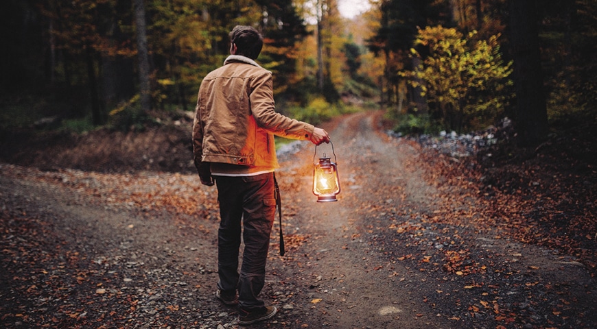 Person with a torch deciding which path to take