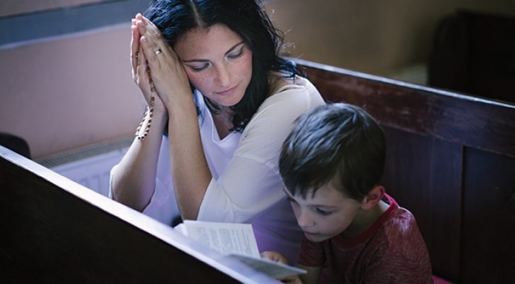 Woman and child kneeling in a church