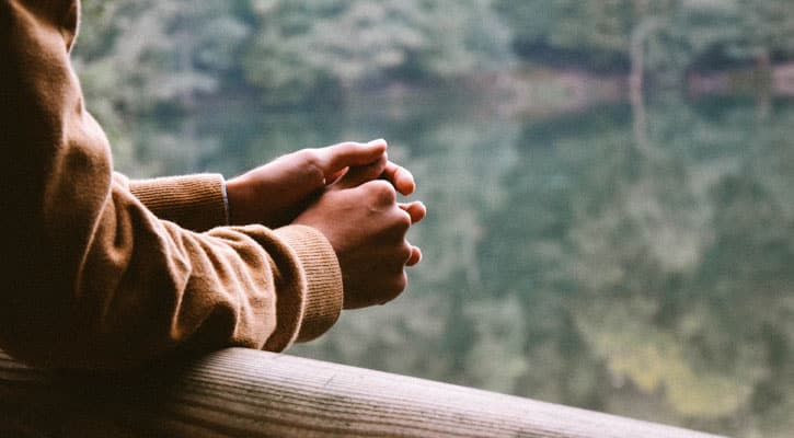 Person with hands on railing showing compassion for yourself