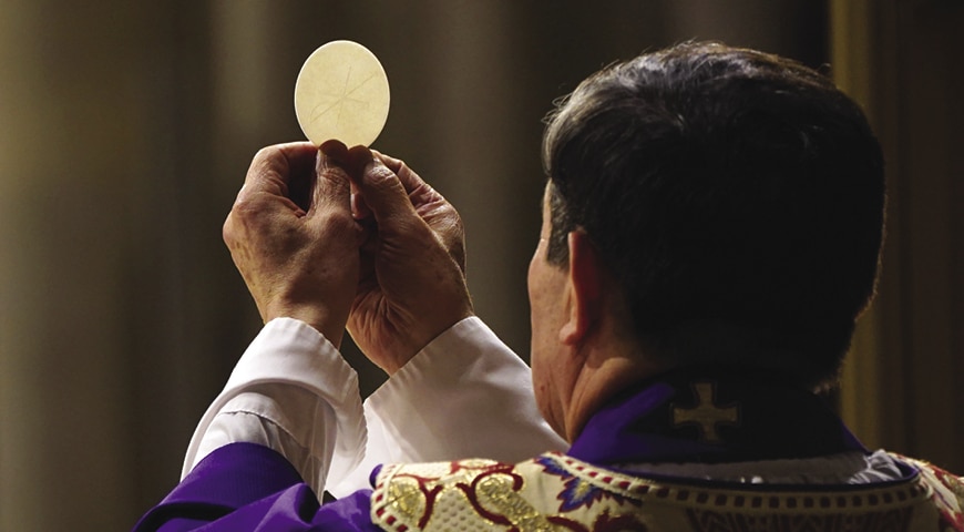Priest holding up Eucharist