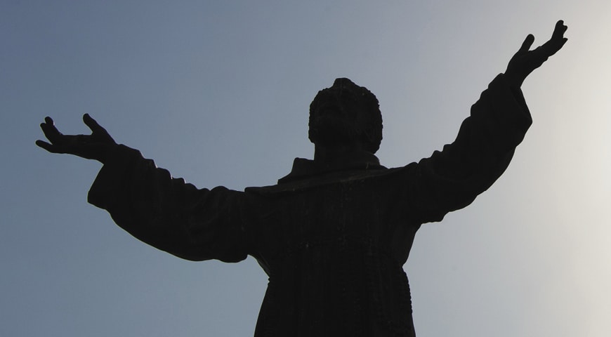 Statue of Saint Francis raising arms to God