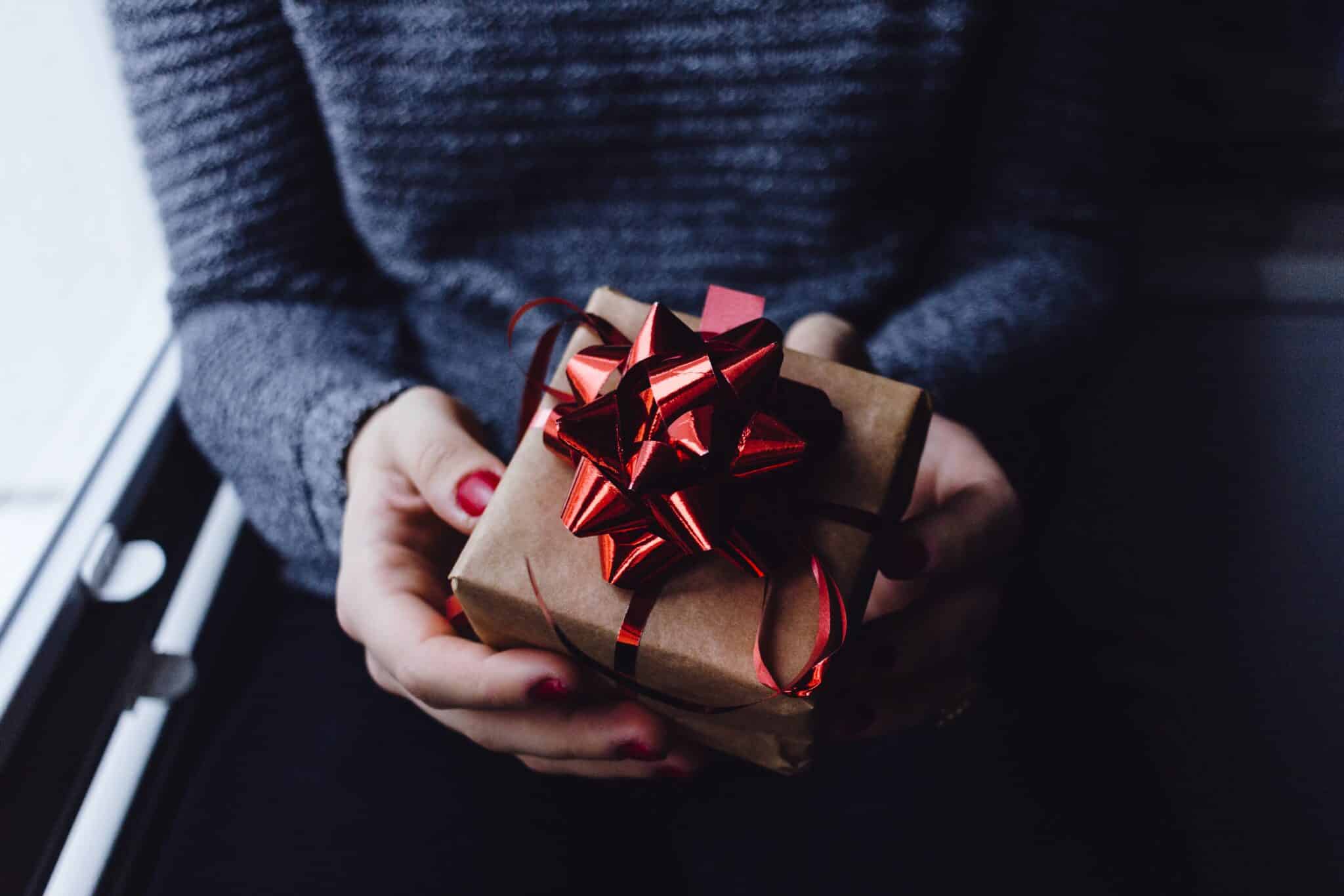 woman holds a gift | Photo by freestocks on Unsplash