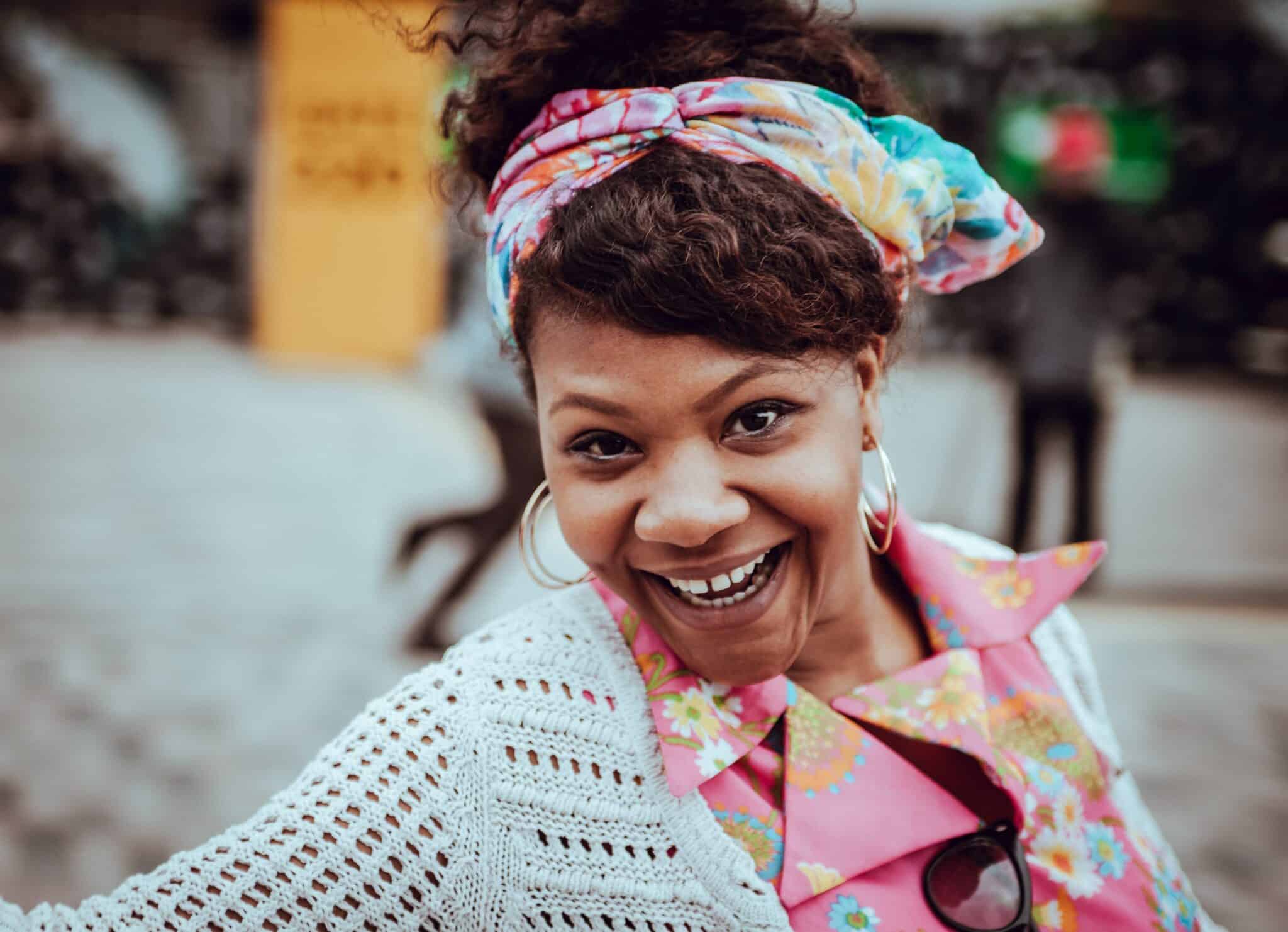 Woman smiling broadly | Clem Onojeghuo/ Unsplash