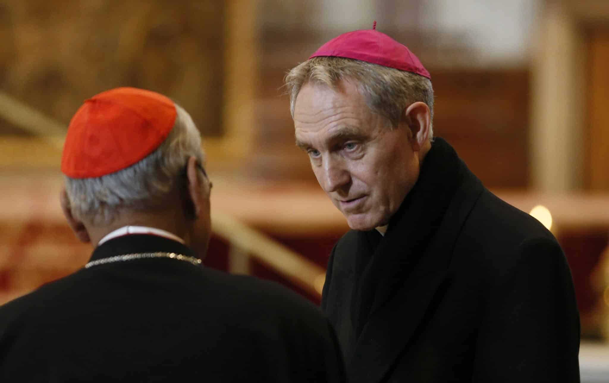 Archbishop Georg Gänswein, right, who was private secretary to Pope Benedict XVI, talks with Cardinal Malcolm Ranjith of Colombo, Sri Lanka, as people pay their respects at the body of Pope Benedict in St. Peter's Basilica at the Vatican Jan. 4, 2023. (CNS photo/Paul Haring)