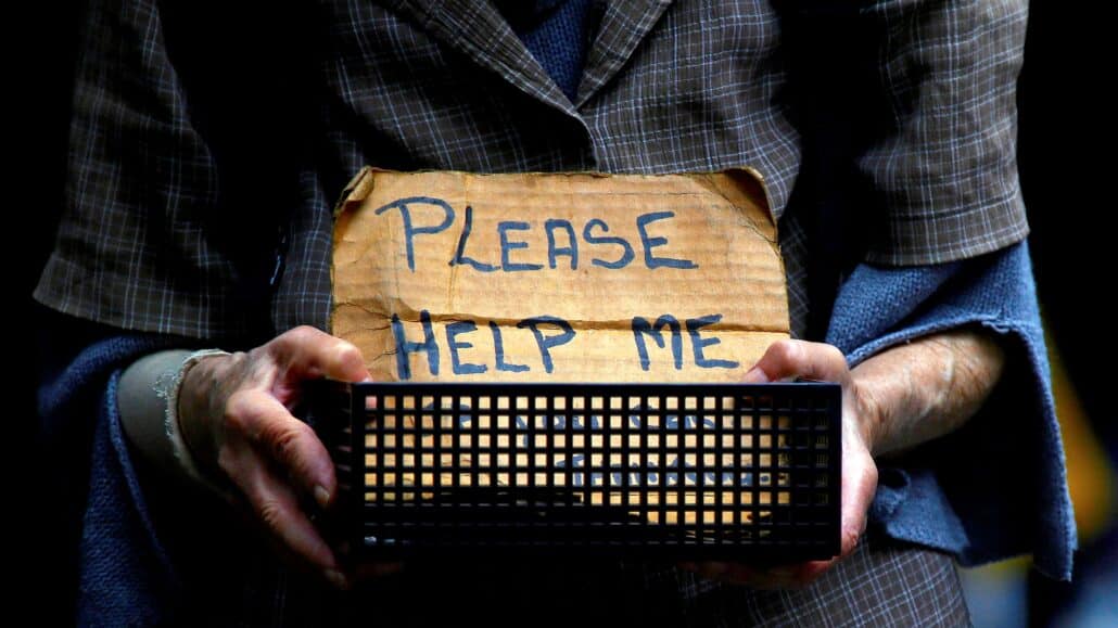 A homeless woman holds a container bearing a sign reading "Please Help Me" as she begs for money on a street in Sydney Oct. 28, 2016. In a pre-election statement, Australian bishops did not endorse an political platform, but said voters should consider candidates who might prioritize people who need palliative care, those in low-paying and insecure jobs, First Nations peoples, asylum-seekers and refugees. (CNS photo/David Gray, Reuters)