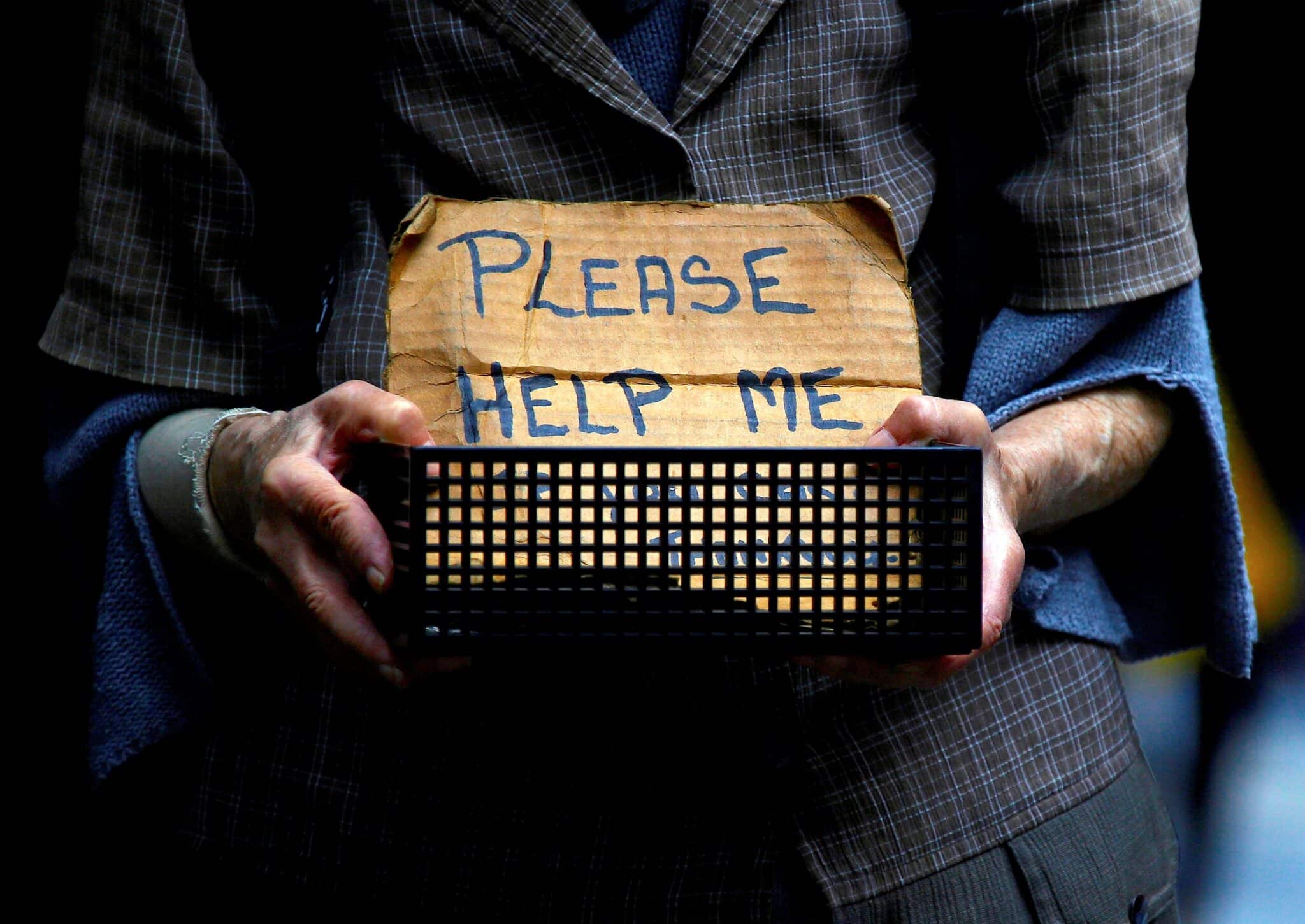 A homeless woman holds a container bearing a sign reading "Please Help Me" as she begs for money on a street in Sydney Oct. 28, 2016. In a pre-election statement, Australian bishops did not endorse an political platform, but said voters should consider candidates who might prioritize people who need palliative care, those in low-paying and insecure jobs, First Nations peoples, asylum-seekers and refugees. (CNS photo/David Gray, Reuters)