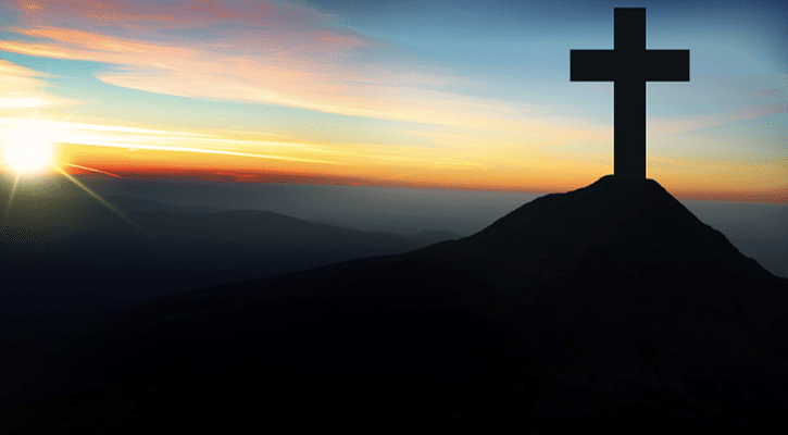 Cross on a mountain with the sunset
